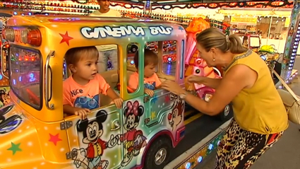 Niños montados en una atracción de la Feria de Mérida