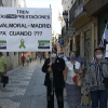 Miembros de Milana Bonita con pancartas reclamando un tren digno en las calles de Badajoz