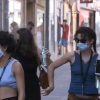 Jóvenes usando las mascarillas en la calle.