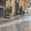 Sombrillas tiradas en una calle debido a la lluvia
