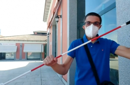 El pacense Alejandro Martínez levanta el bastón bicolor que le identifica como sordociego 