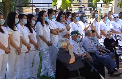 personal sanitarios y mayores en el exterior de la residencia durante un acto de homenaje