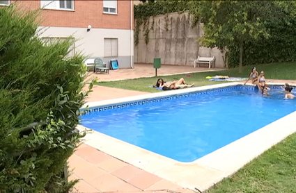 Varios vecinos de una comunidad de propietarios se bañan en la piscina común
