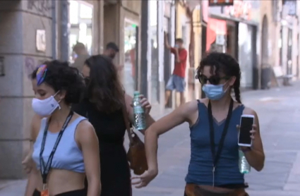 Jóvenes usando las mascarillas en la calle.