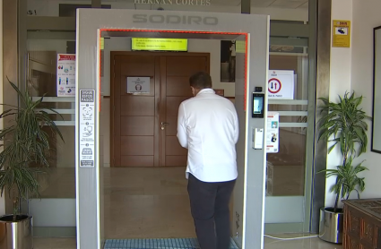 Persona pasando por el arco anticovid instalado en la entrada de la Residencia Hernán Cortés