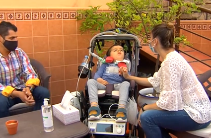 Alberto y sus padres sentados en la terraza de su casa