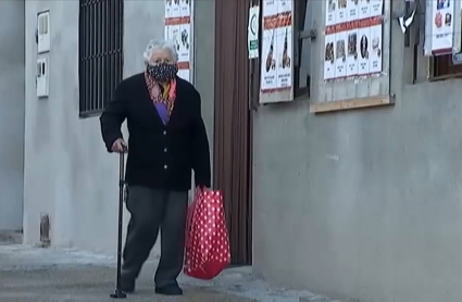 Anciano paseando en un pueblo con mascarilla