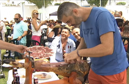 Un hombre cortando jamón en la Fiesta del Jamón de Monesterio