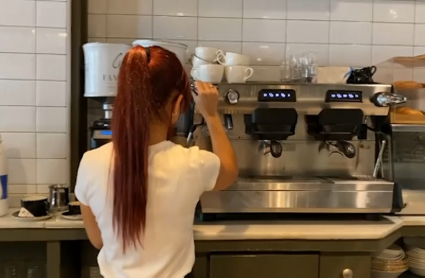 Camarera preparando un café en una cafetería