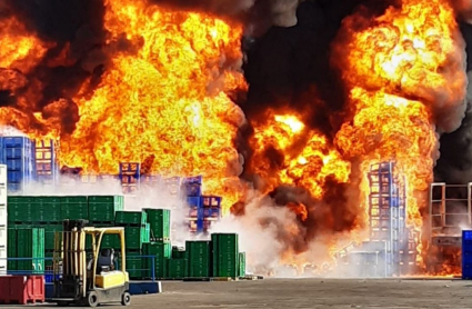 Palots de fruta ardiendo en el exterior de la central hortofrutícola