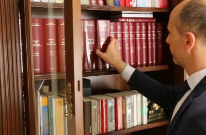 Notario de Jarandilla de la Vera consultado un manual de derecho de su biblioteca particular