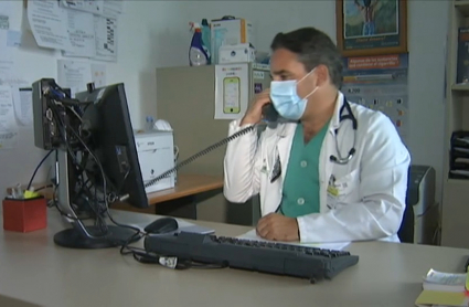 Un médico atiende una consulta por teléfono