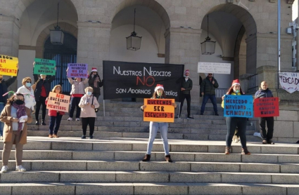 Comerciantes cacereños en la escalinata del Ayuntamiento, manifestándose en contra del Mercado Navideño en la Plaza Mayor