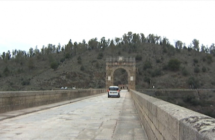 Coches circulando por el puente romano de Alcántara