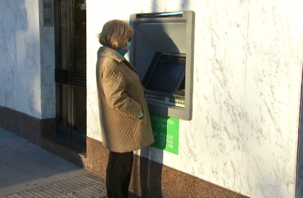 Mujer intentando sacar dinero de un cajero automático