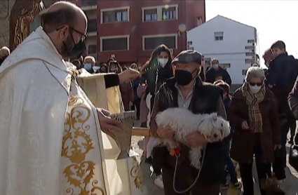 El párroco de Valverde del Fresno bendice con agua al perro de un vecino del municipio.