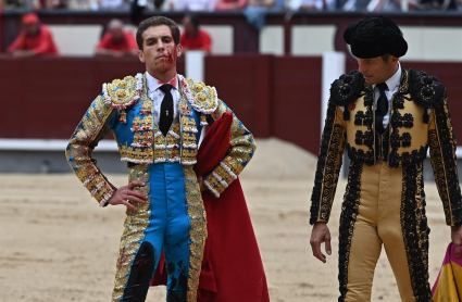 El diestro Ginés Marín (i), tras sufrir un revolcón con su primero de la tarde durante la corrida de la Feria de San Isidro hoy en la plaza de Lasa Ventas, en Madrid.
