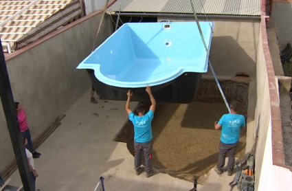 Trabajadores instalan una piscina prefabricada