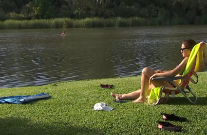 Mujer tomando el sol y refrescándose en la playa fluvial de Medellín