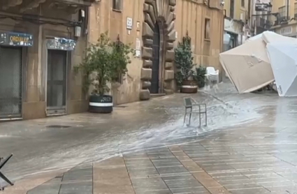 Sombrillas tiradas en una calle debido a la lluvia